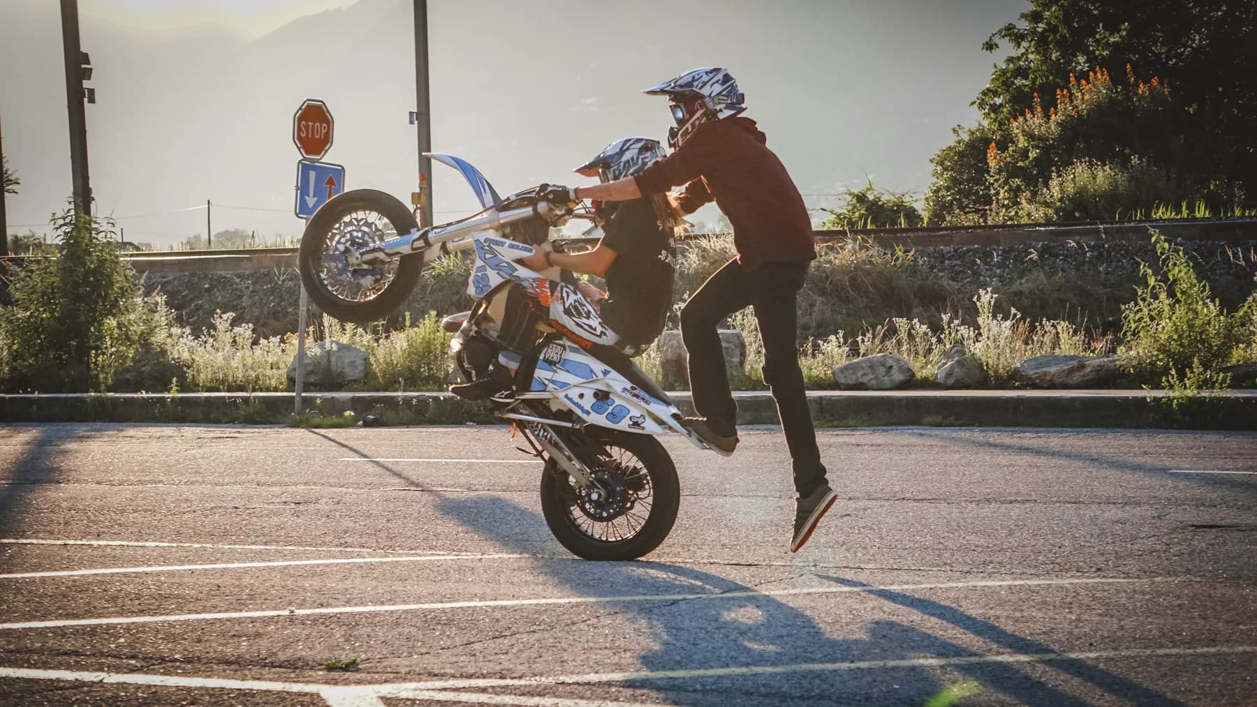 Motorradfahrer bei einem Stunt im Abendlicht