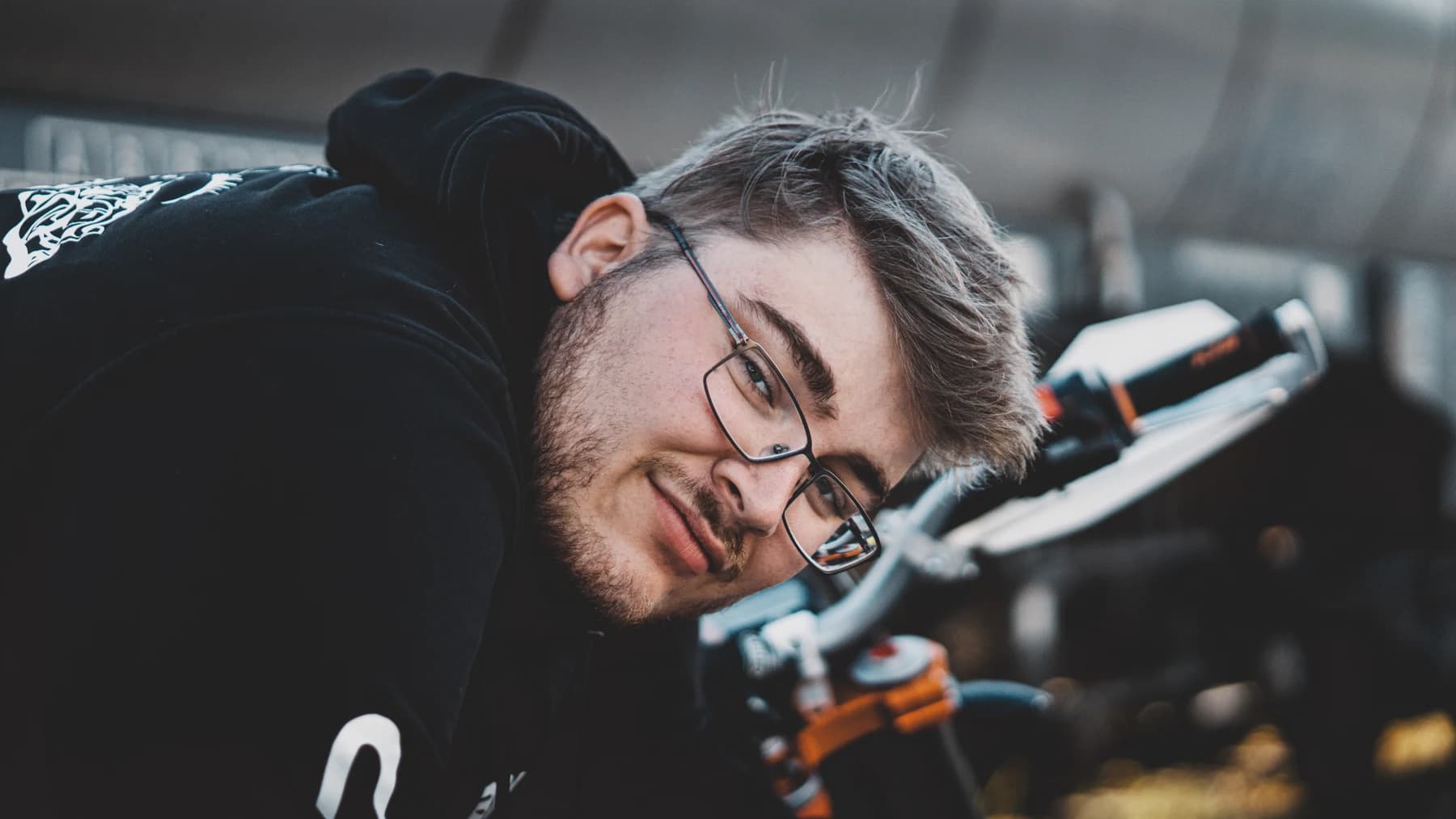 Mann mit Brille neben einem Motorrad
