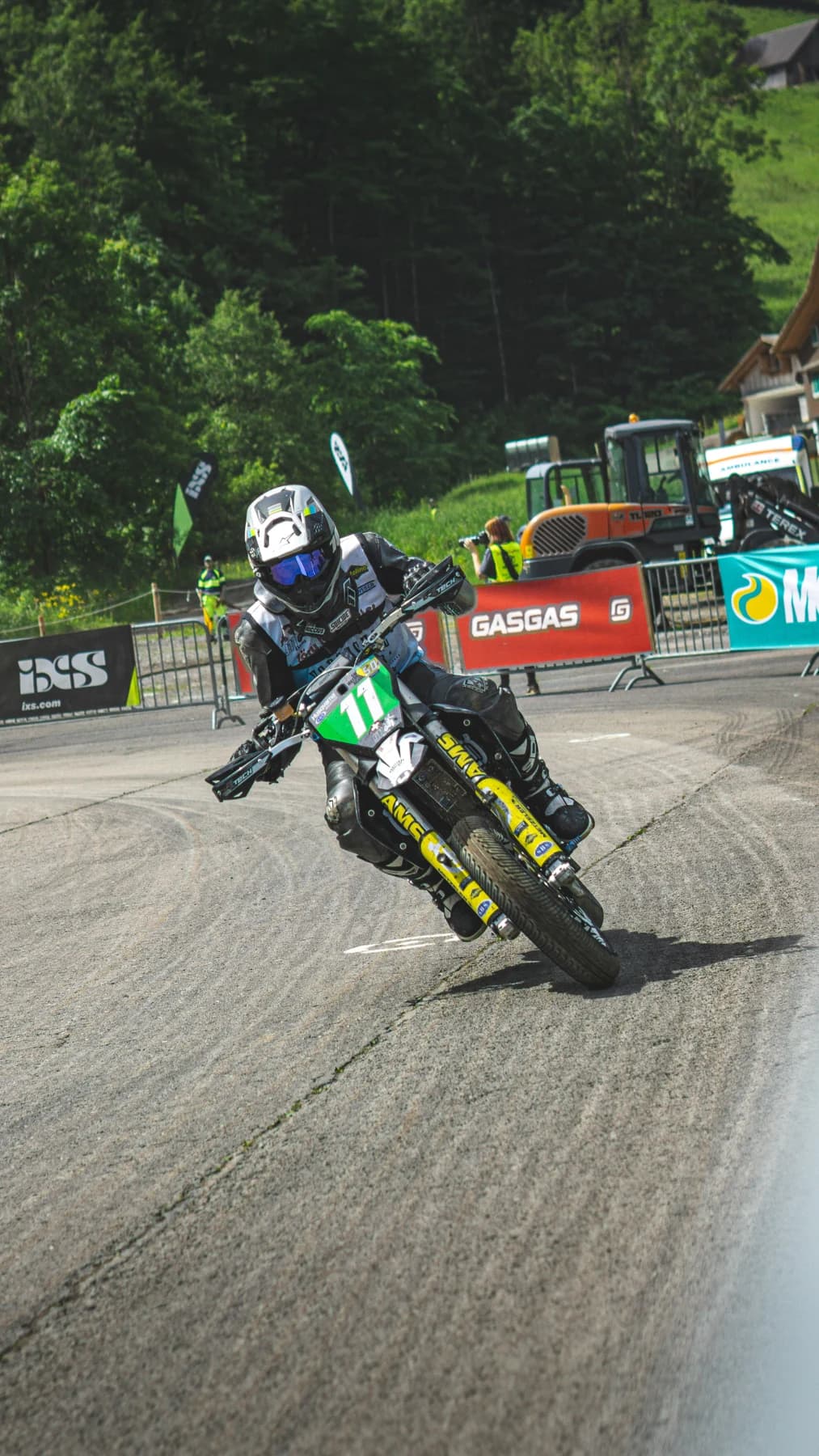 Motorradfahrer in Schräglage vor einer Zuschauertribüne