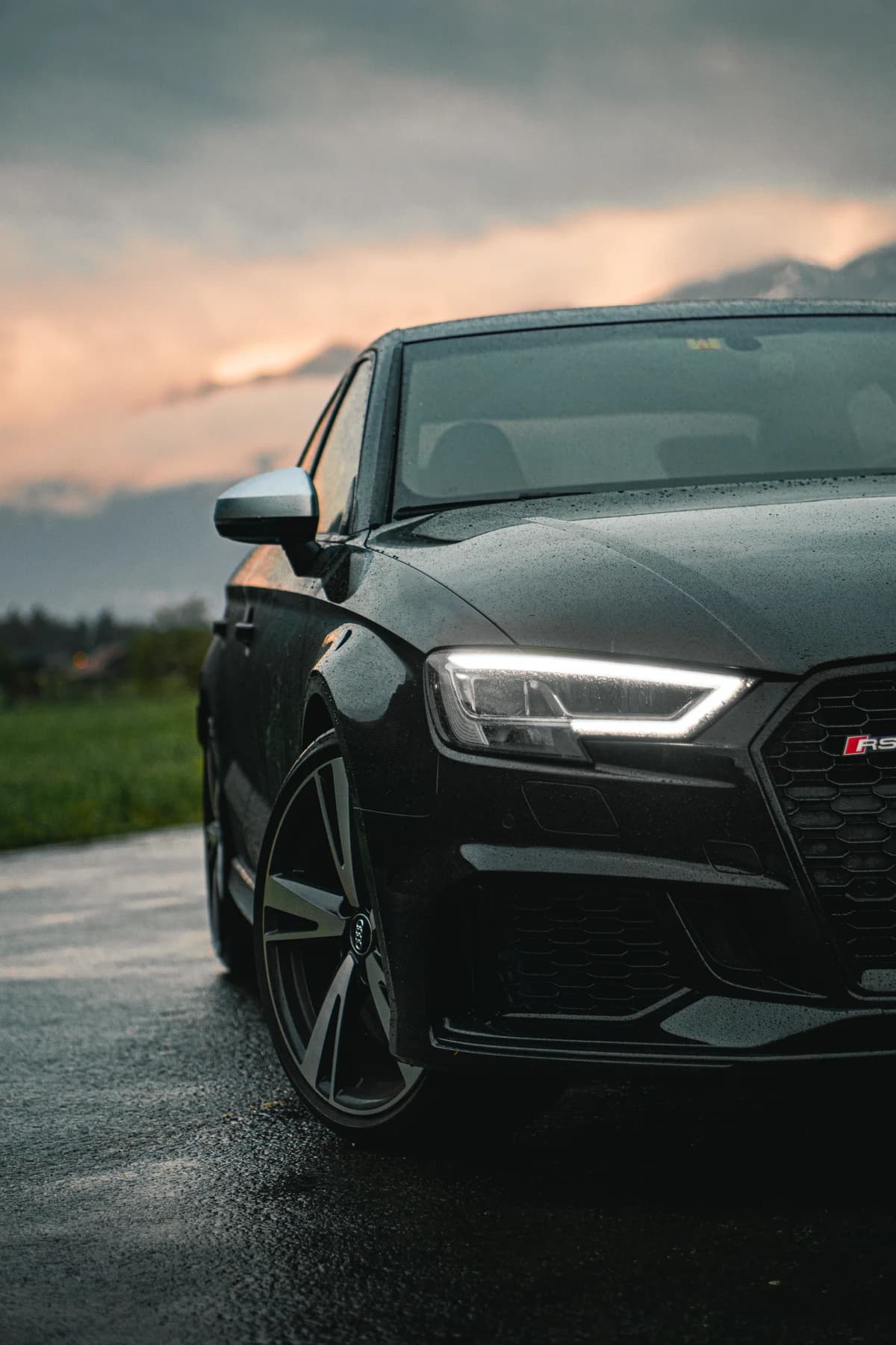 Frontansicht eines dunklen Audi RS3 im Abendlicht