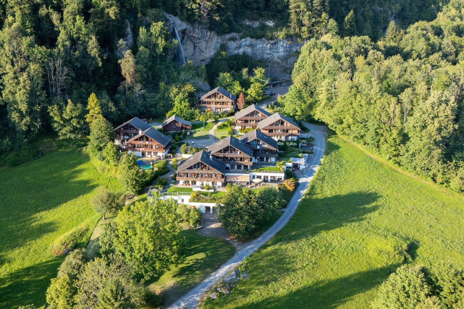 Luftaufnahme eines Dorfes zwischen Wiesen und Wald
