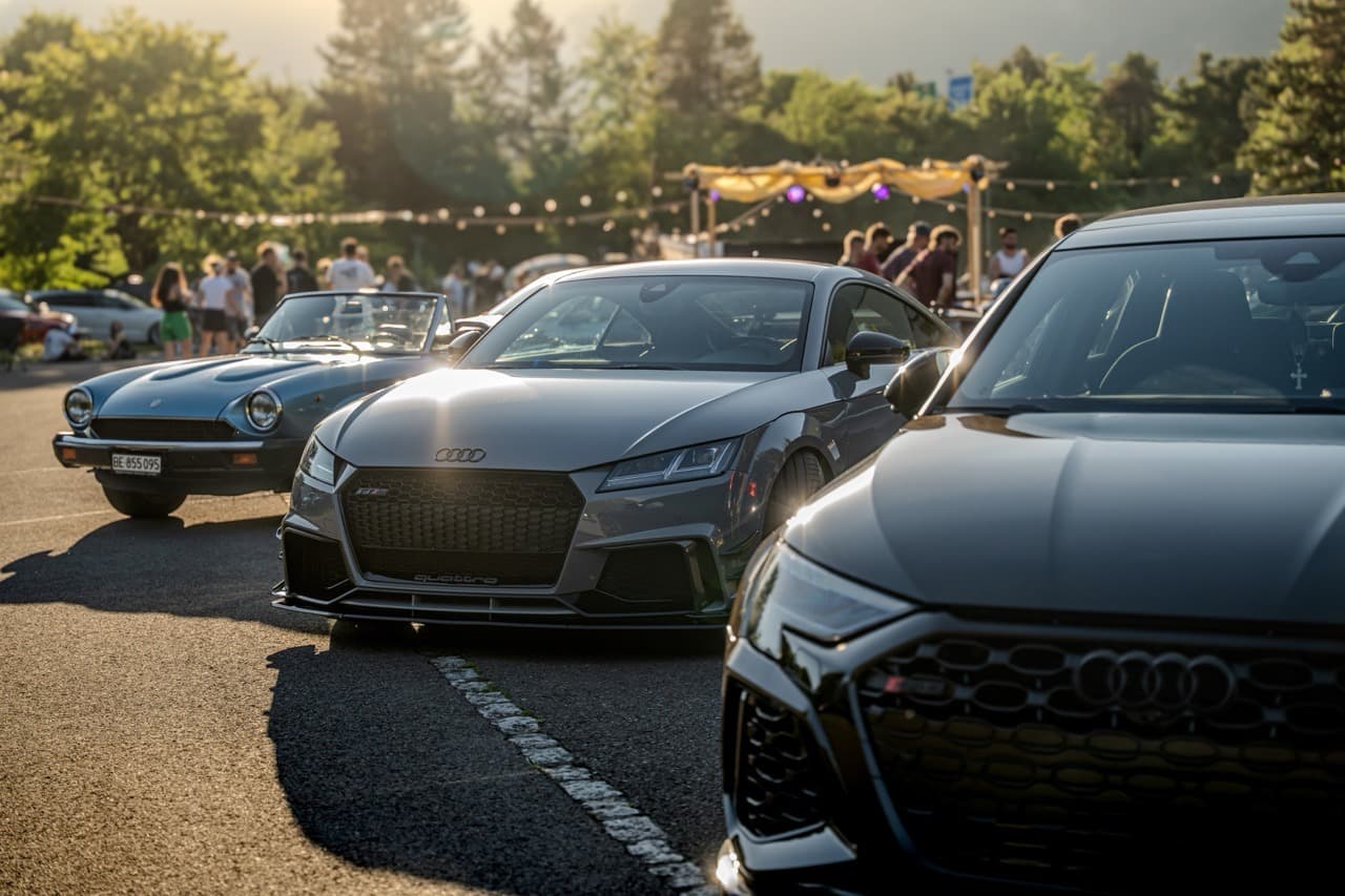 Fahrzeuge bei einem Treffen im Abendlicht
